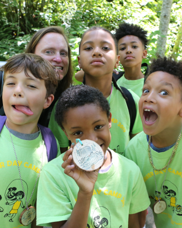 group of children in green t-shirts smiling widely at the camera