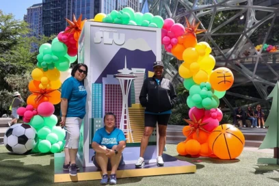 Three women standing in front of balloon arch